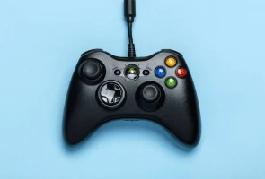 Black gaming controller on blue background